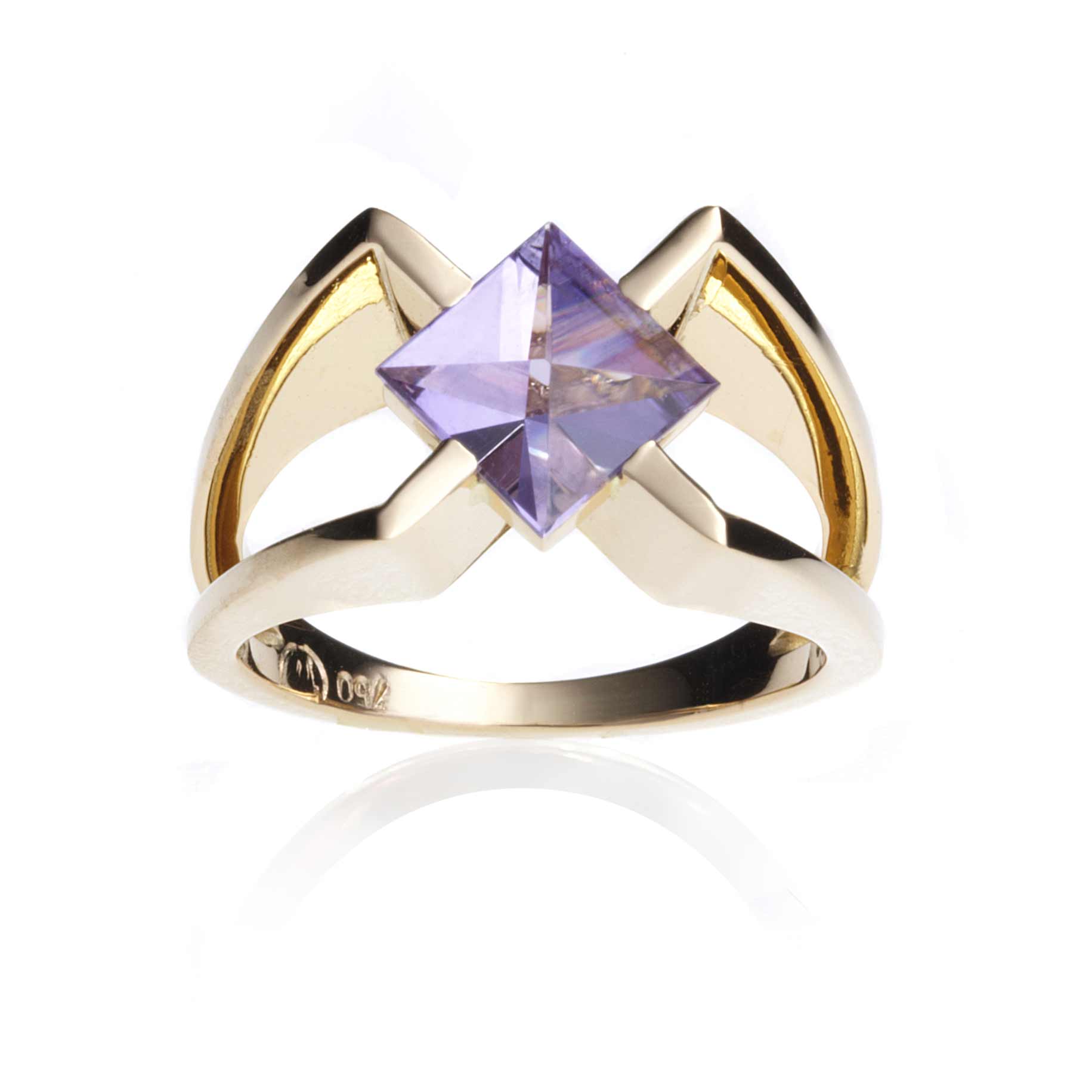 An 18 carat golden ring in a colour shade between yellow and rose gold. This ring encloses a gemstone, an amethyst, cut in Context cut.