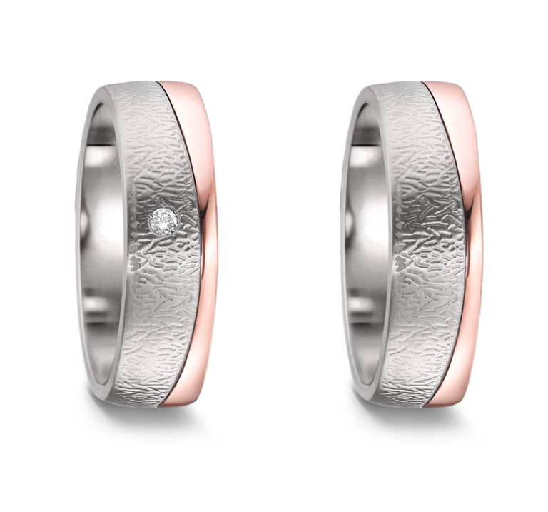 A pair of wedding or friendship rings crafted in titanium and combined with 18 karat rose gold. The ladies' model has a small diamond.