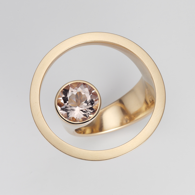 18 karat gold ring, in top view, consisting of an open circle and a freestanding pink morganite gemstone.