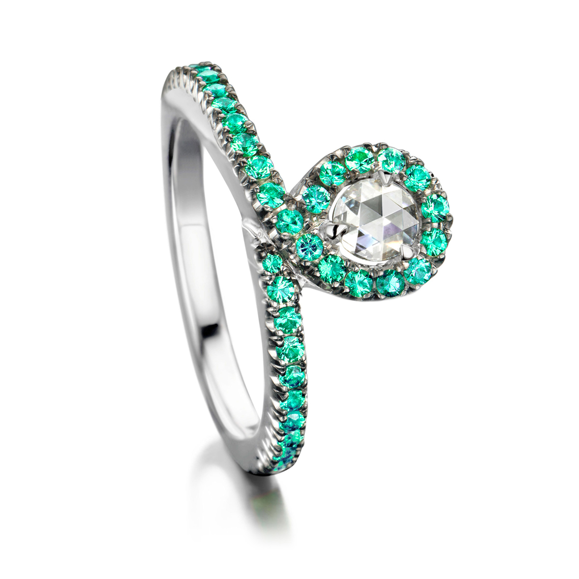 Ring in 18 karat white gold set with a white rose-cut diamond centerstone and top quality emeralds in castle setting.