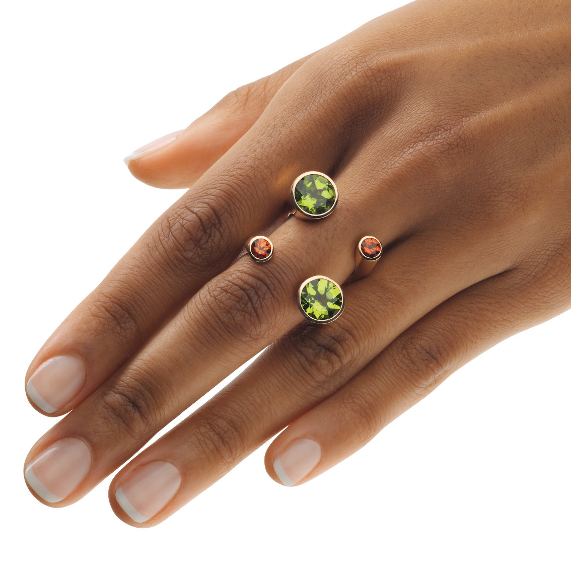 18 karat gold design ring with two orange sapphires and two peridots. The stones appear to be free on the hand.