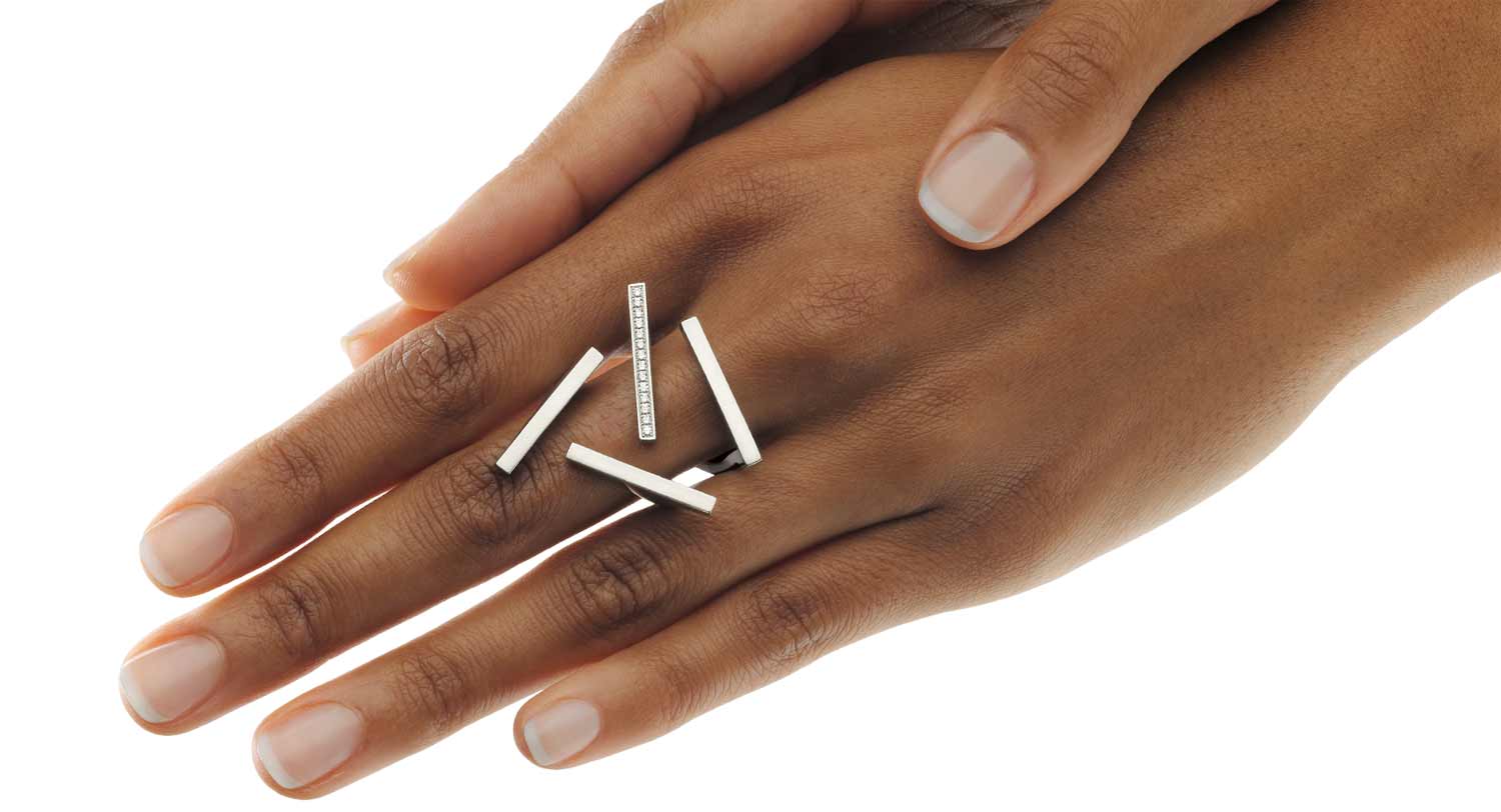 18 karat gold designer ring with four stand-alone lines positioned in four different directions. One line is set with diamonds.